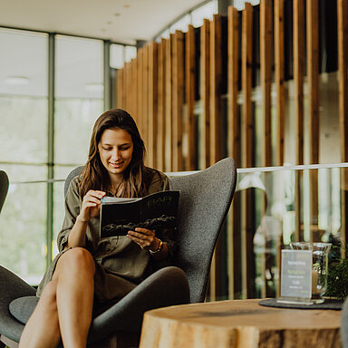 Eine Frau stöbert durch Broschüren und Magazine im Hotel Lürzerhof.