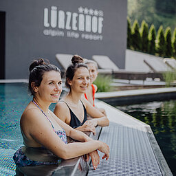 Gäste genießen die Zeit im Outdoorpool im Adults Only Bereich im Wellnesshotel Lürzerhof in Salzburg