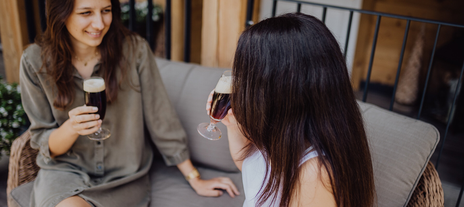Zwei Frauen stoßen mit Getränke auf der Terrasse des Lürzerhofs an.