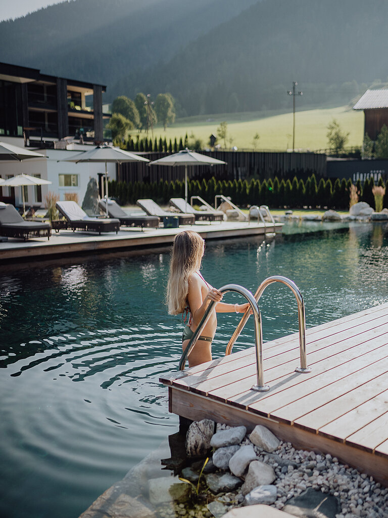 Wellness & SPA Eine Frau geht in den Bergseepool im Lürzerhof Wellnesshotel in Salzburg