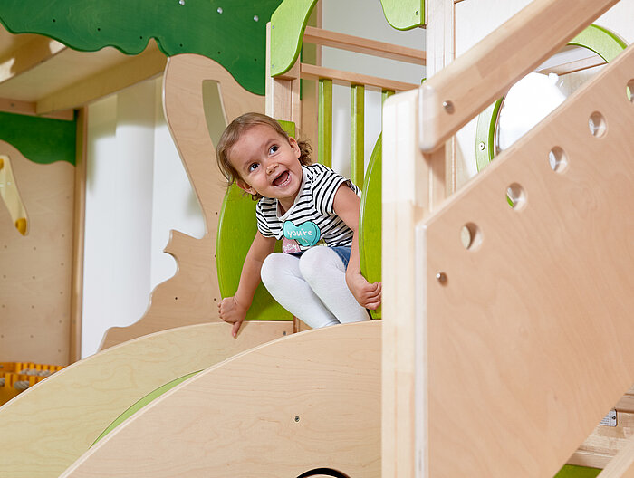 Ein Mädchen beim Rutschen im Spielbereich des Lürzerhofs, dem Familienhotel in Österreich für Urlaub mit Kindern