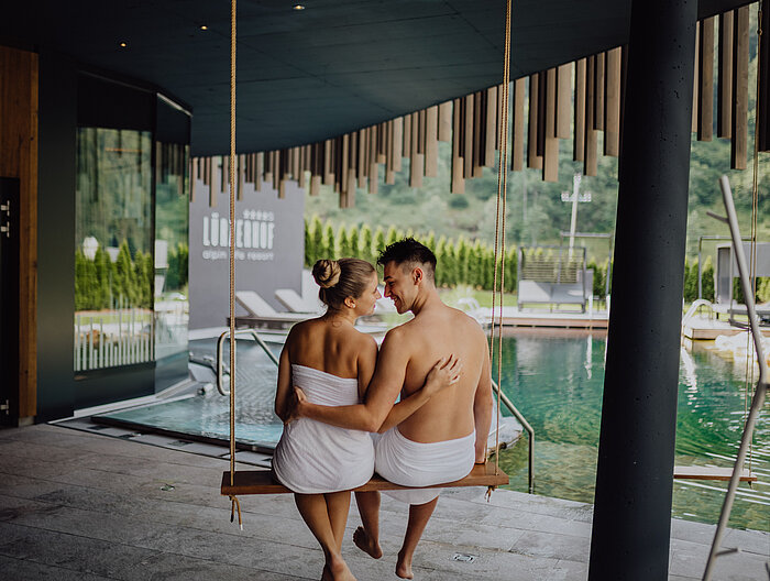 Ein Paar entspannt auf einer Schaukel im Wellnesshotel Lürzerhof in Salzburg.